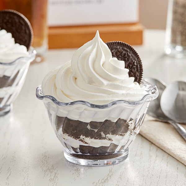Two clear plastic dessert dishes filled with Oreo cookies and whipped cream.