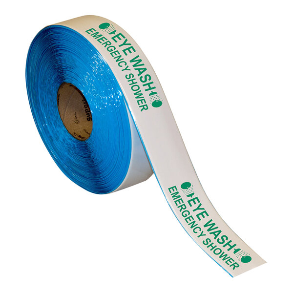 A roll of white and green Superior Mark safety tape with the words "Eye Wash Emergency Shower" in blue.