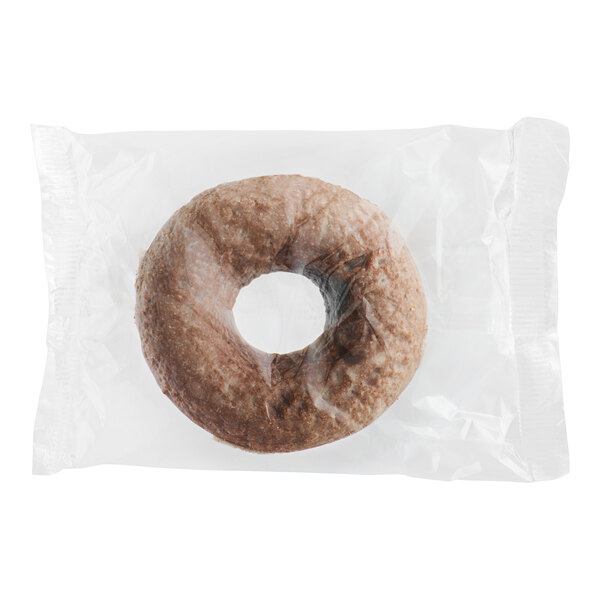 An individually wrapped Southern Roots vegan chocolate cake donut in a plastic wrapper.