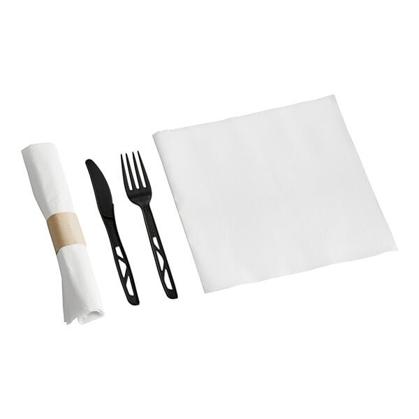 A white napkin with a brown band wrapped around black compostable plastic cutlery.