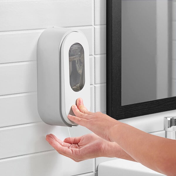 A person using a Dial Versa light gray flex-bag pouch manual dispenser to wash their hands.