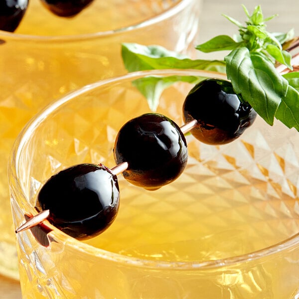 A close up of two drinks garnished with Luxardo Original Maraschino cherries.
