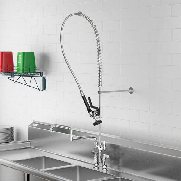 A Regency deck-mounted pre-rinse faucet with a double-jointed hose above a sink.