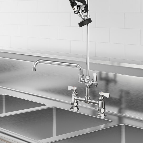 A stainless steel sink with a Regency pre-rinse add-on faucet and swing spout.