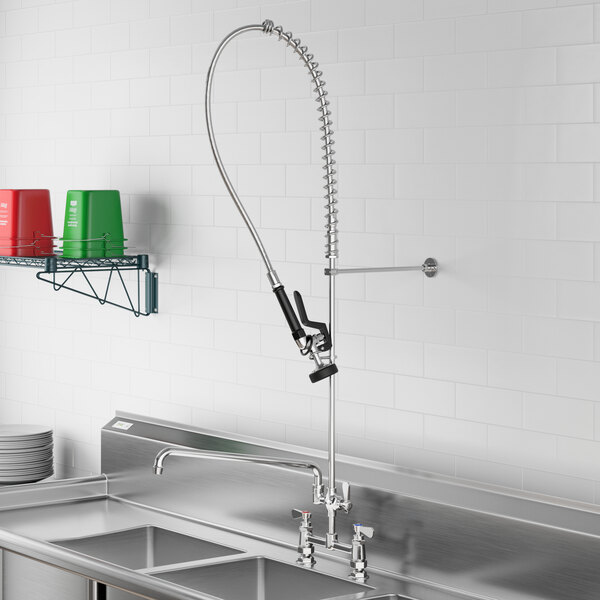 A stainless steel Regency sink with a deck-mounted pre-rinse faucet and add-on faucet hose.