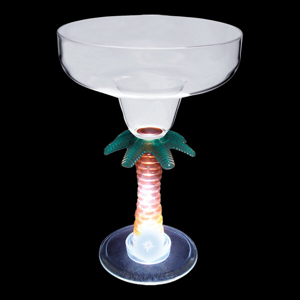 A clear plastic margarita cup with a palm tree shaped stem and white LED light.