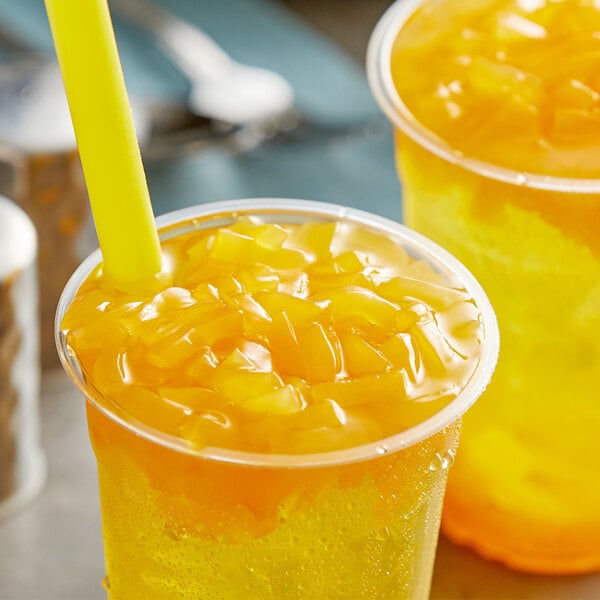 A couple of plastic cups of orange bubble tea with Fanale Mango Jelly Topping and straws.