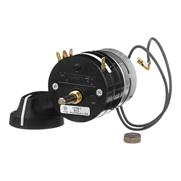 A black round electric motor with wires and a gold knob.