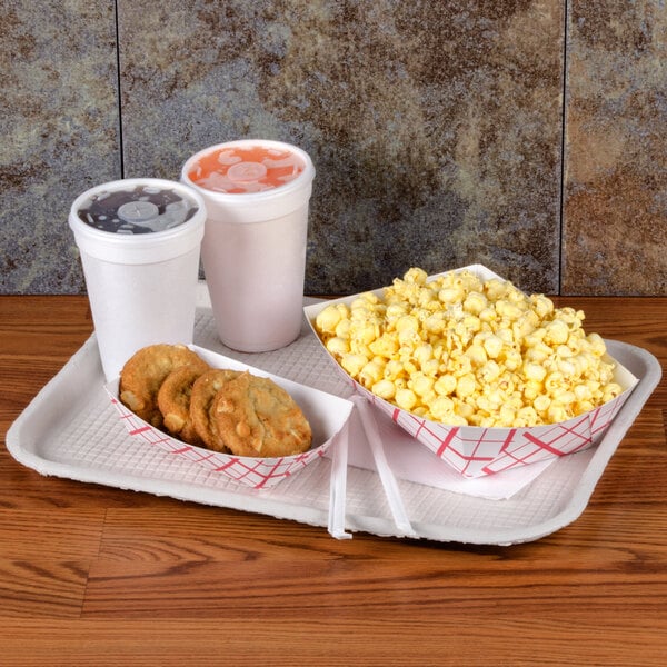 A Huhtamaki Chinet molded fiber tray with popcorn and cookies on a table.