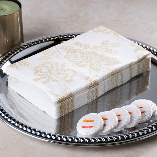 A stack of Hoffmaster Linen-Like Gold Prestige guest towels on a silver tray.