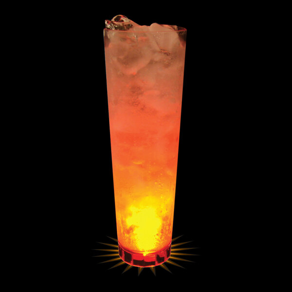 A close up of a 32 oz. plastic cup with orange liquid, ice, and an orange LED light.