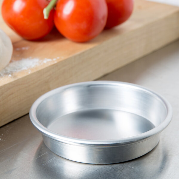 An American Metalcraft heavy weight aluminum pizza pan with tomatoes on it.
