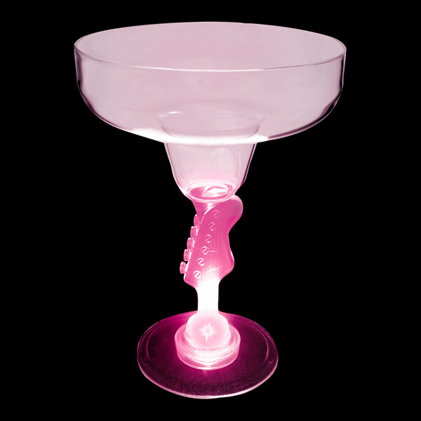 A customizable plastic guitar stem margarita cup with a pink LED light on a table.
