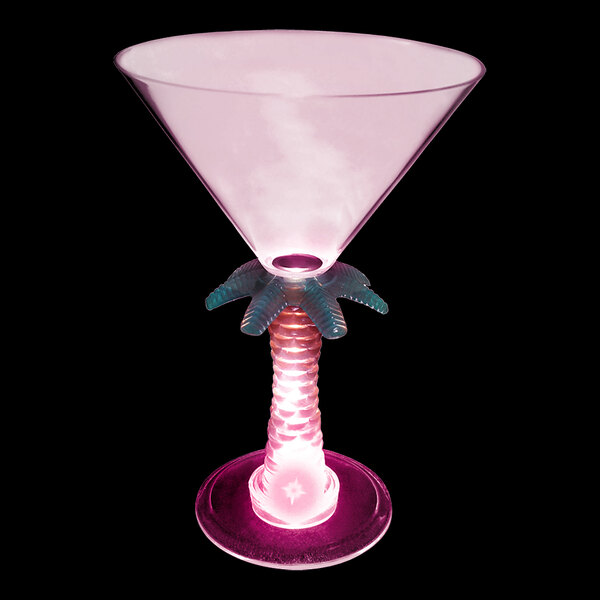 A pink plastic martini glass with a lighted palm tree and a pink and blue base.