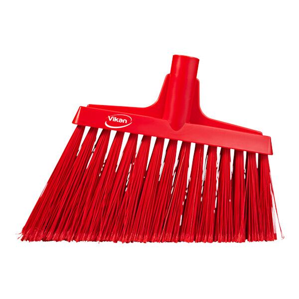 A red Vikan angled broom head with long bristles.
