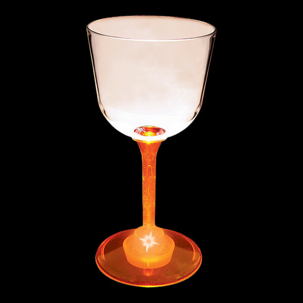 A close-up of a 7 oz. plastic wine glass with an orange LED light inside.