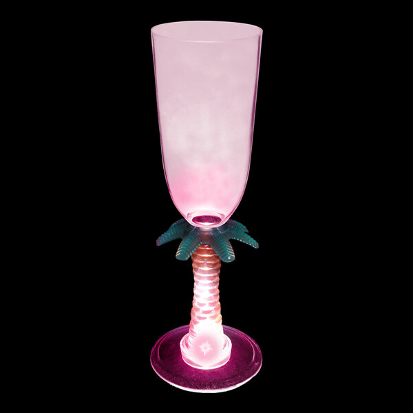 A pink plastic champagne glass with a palm tree-shaped stem with a pink LED light.