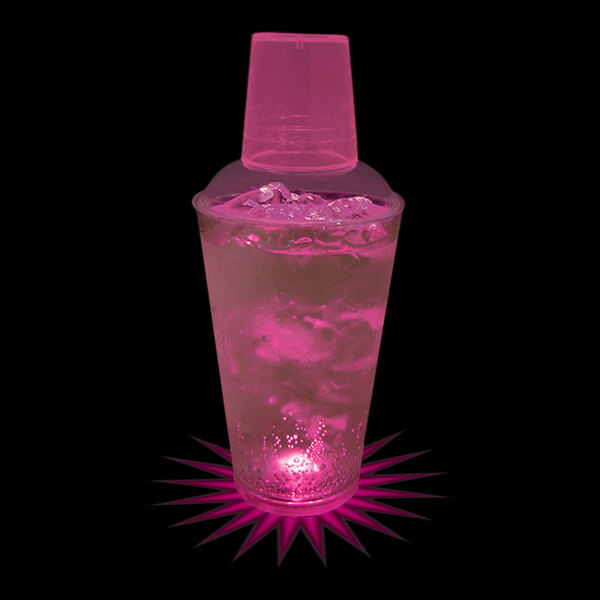 A pink customizable plastic shaker with ice and water next to a pink plastic cup.