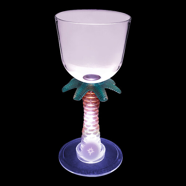 A clear plastic stem wine cup with a palm tree and purple LED light.