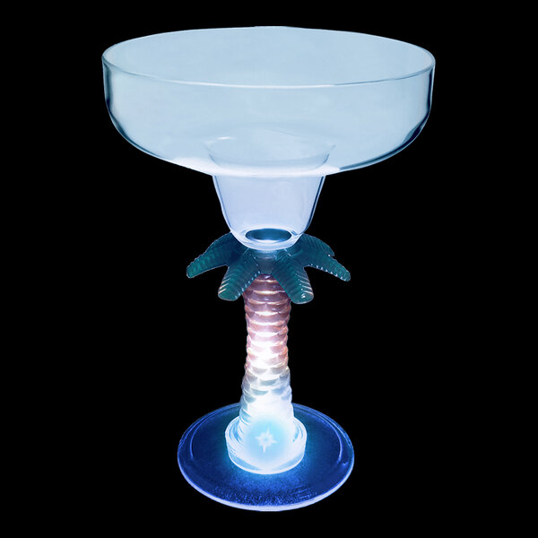 A clear plastic margarita glass with a palm tree stem with a blue LED light.