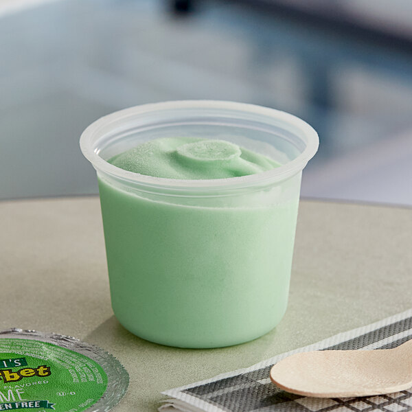 A plastic container of Luigi's lime sherbet ice cups filled with green sherbet.