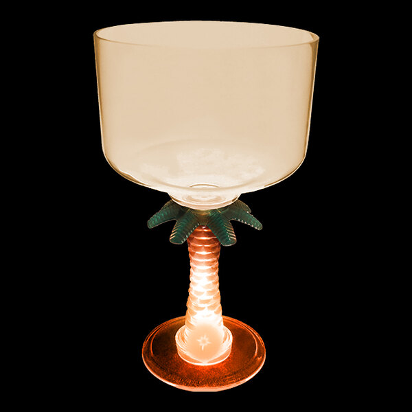 A clear plastic margarita glass with a palm tree stem and an orange LED light.