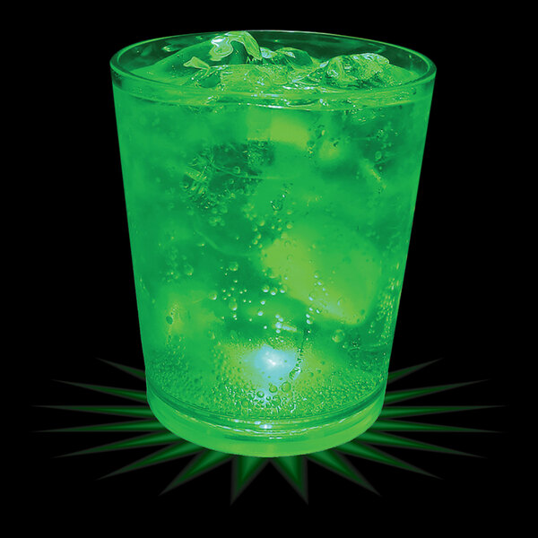 A 12 oz. plastic rocks cup with a green LED light filled with a green drink and ice.