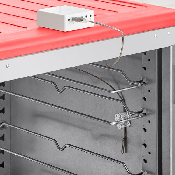 A white box with wires for the VersaTile Remote WiFi-Enabled Oven Kit on a red surface.