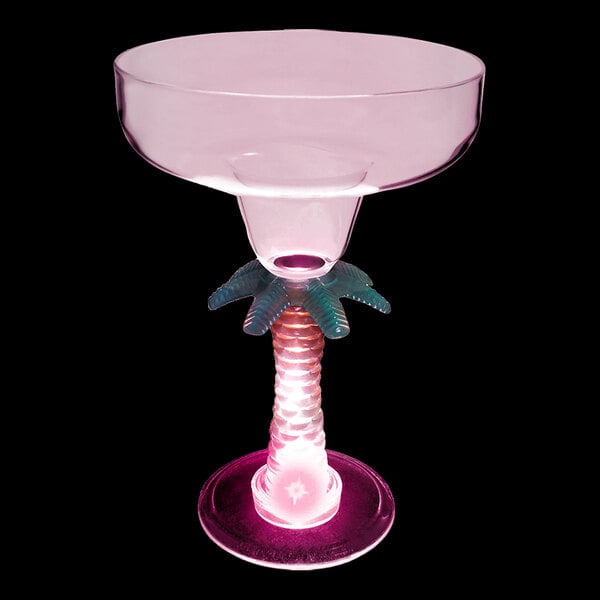 A clear plastic margarita glass with a palm tree stem and a pink LED light.