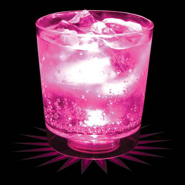 A customizable plastic rocks cup with a pink drink and ice cubes.