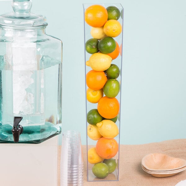 A Cal-Mil clear acrylic square accent display vase filled with oranges and lemons.