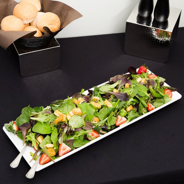 An American Metalcraft trapezoid melamine serving platter with a salad of strawberries and vegetables.