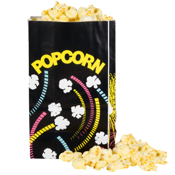 A black Bagcraft Packaging popcorn bag with yellow and white funburst design flowers.