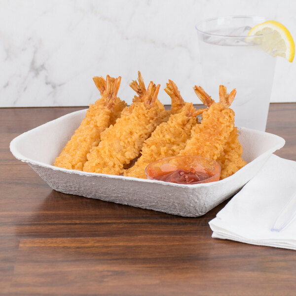 A Huhtamaki Chinet rectangular paper food tray with fried shrimp and sauce on a white surface.