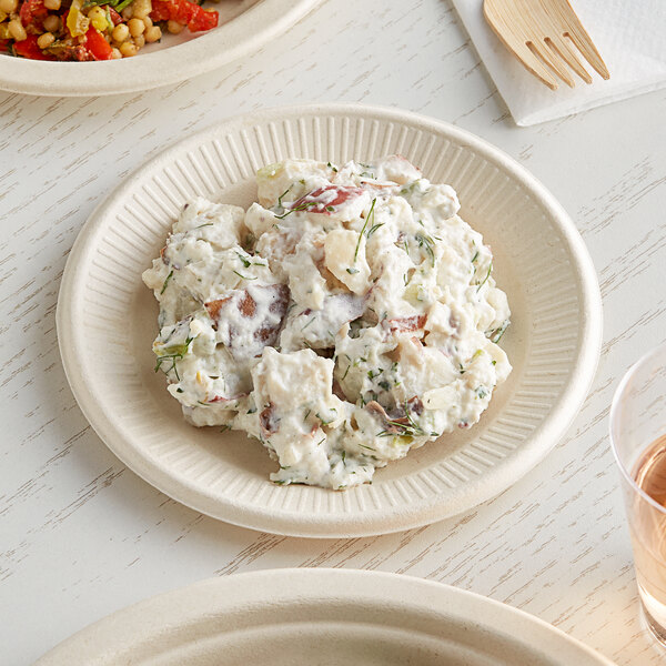 A World Centric compostable plate with potato salad, on a table.