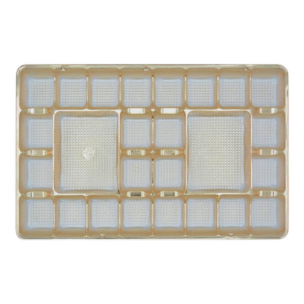 A gold tray with 26 square cavities.
