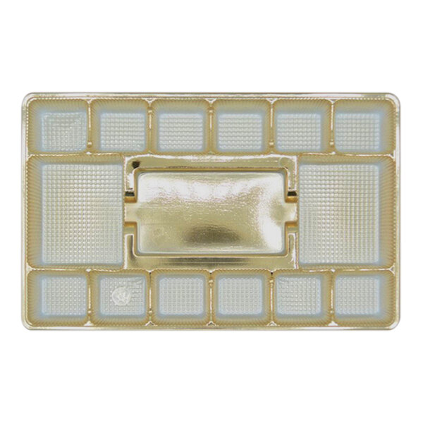 A gold candy tray with 15 white squares on it.