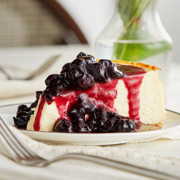 A slice of cheesecake with Oregon Fruit Blueberry Filling and Topping on a plate.