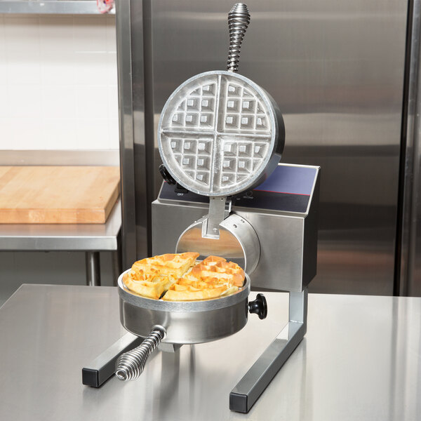 A Nemco Belgian waffle maker on a counter with waffles in a bowl.