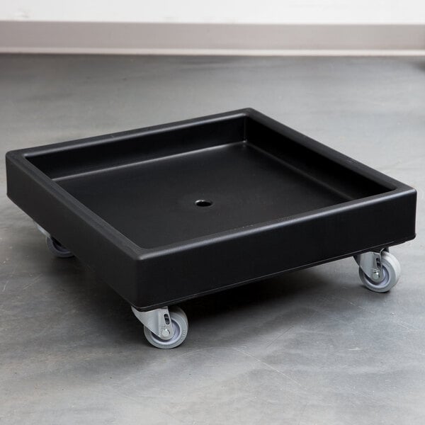 A black square Cambro dolly with wheels.