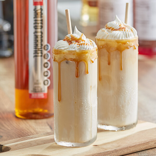 Two glasses of liquid with caramel sauce and whipped cream made with SHOTT Salted Caramel Flavoring Syrup.