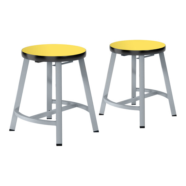 A pair of National Public Seating Titan lab stools with yellow high-pressure laminate seats and metal legs.