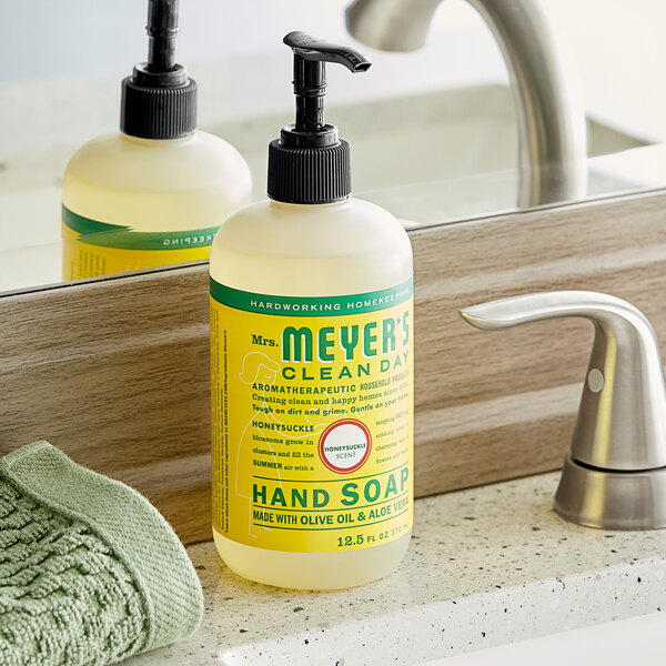 A white Mrs. Meyer's hand soap bottle with a green label and pump on a counter.