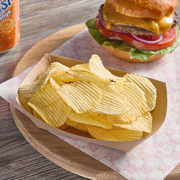 A wooden plate with a cheeseburger and a bowl of Ruffles Original potato chips.