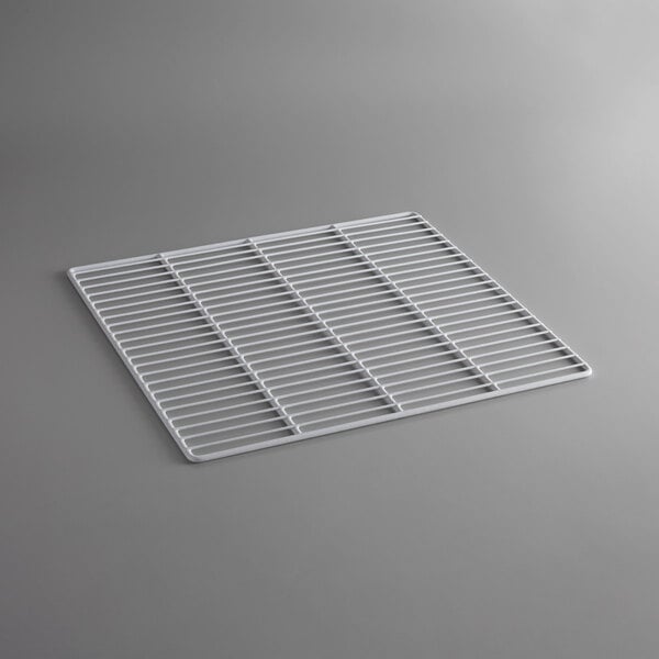 A white coated wire shelf on a gray surface.