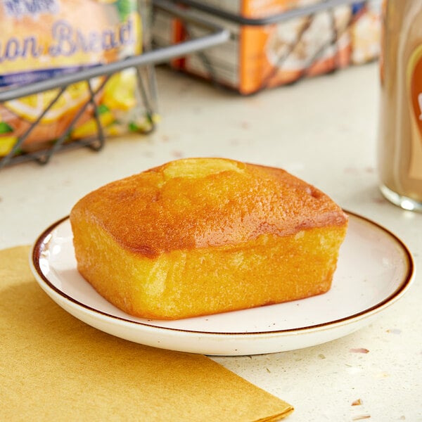An individually wrapped piece of Ne-Mo's Zesty Lemon Cake Bread on a plate.