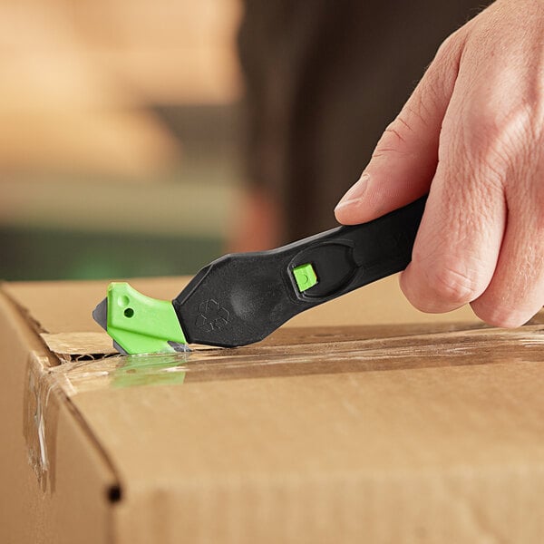 A person using a Klever Kutter EcoXChange to cut a box.