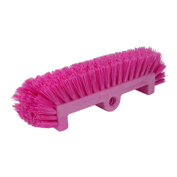 A close-up of a Carlisle Sparta pink floor scrub brush with end bristles.