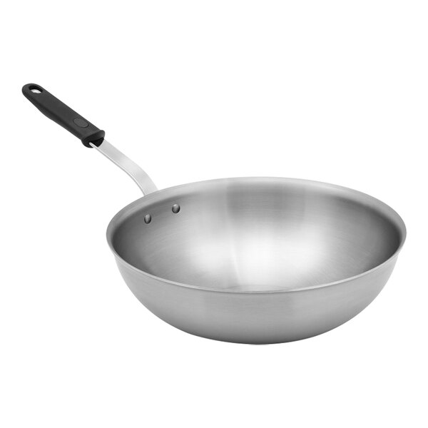 A Vollrath stainless steel stir fry pan with a black silicone handle.