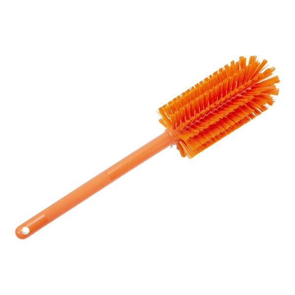 A close up of a Carlisle orange bottle cleaning brush with a white handle.